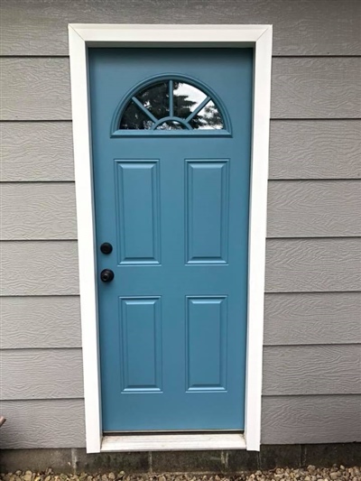 A blue door with a white frame and an arched window at the top, set against gray horizontal siding.