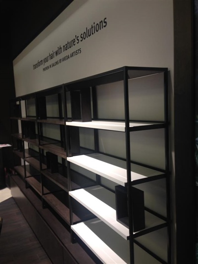 A retail display with empty, illuminated shelves and a sign above that reads, "Empowered to offer expert solutions."