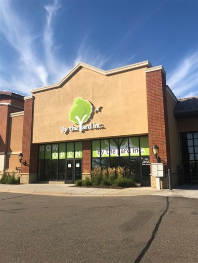 Storefront of a building with a green tree logo and "Life Time Athletic" sign, featuring large windows and surrounded by a clear blue sky.