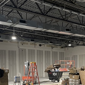 Black-painted bar joist ceiling above unfinished retail walls during Adidas store construction in Eagan, MN