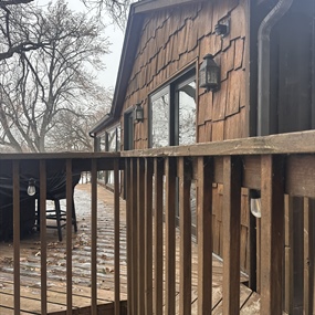 Weathered cedar shake siding and wood deck before exterior staining at a Fish Lake cabin in Maple Grove