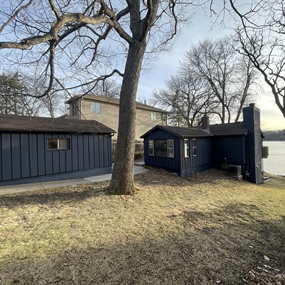 Finished Hail Navy cedar shake siding on the lakeside home and detached garage in Maple Grove