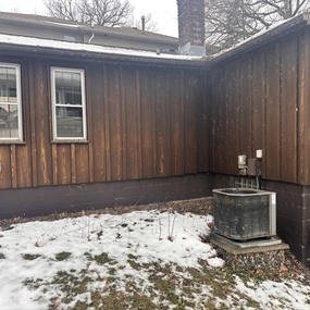 Aged cedar siding and snowy side yard before the Maple Grove lake cabin exterior restoration