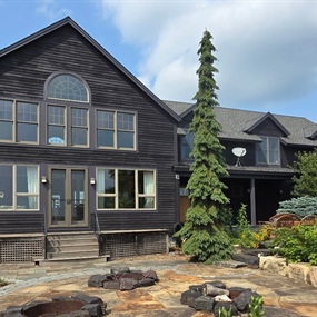 Front entry and dark wood siding on a Dayton farmhouse after preventative exterior staining