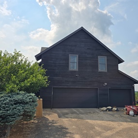 Black stained garage elevation on a Dayton farmhouse after high-reach wood siding maintenance