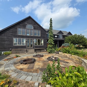 Front patio view of a Dayton farmhouse with dark wood siding before exterior maintenance coating