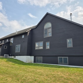 Black wood siding on a large Dayton farmhouse after exterior maintenance staining by Get Fresh Paint