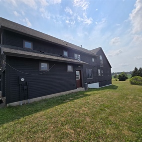 Finished Black Noir wood siding on the side gable of a Dayton farmhouse exterior staining project