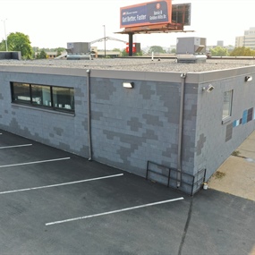 Finished Master Spas retail facade with gray masonry coating and restored storefront entrance