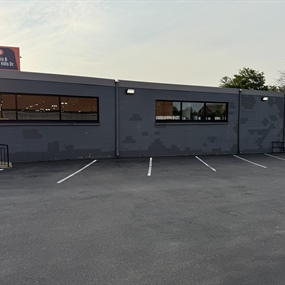 Wide view of Master Spas commercial building before exterior painting and rust treatment work