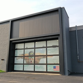 Commercial garage bay facade after masonry painting and dark trim refresh for Master Spas